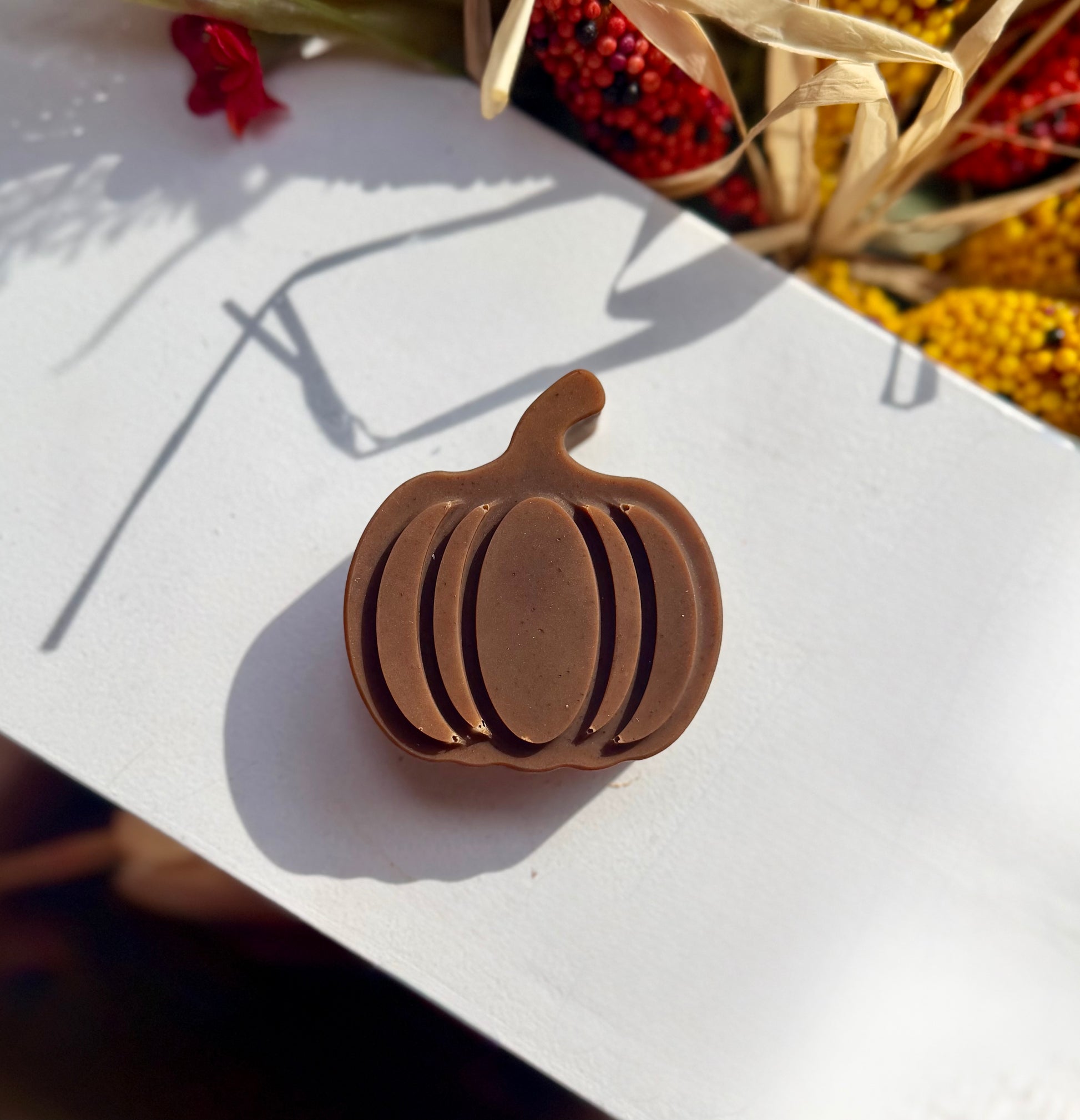 A small brown pumpkin shaped soap sitting on a white background.