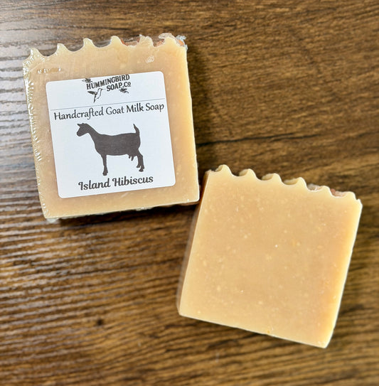 Two bars of tan soap. One is shrink wrapped with a label. 