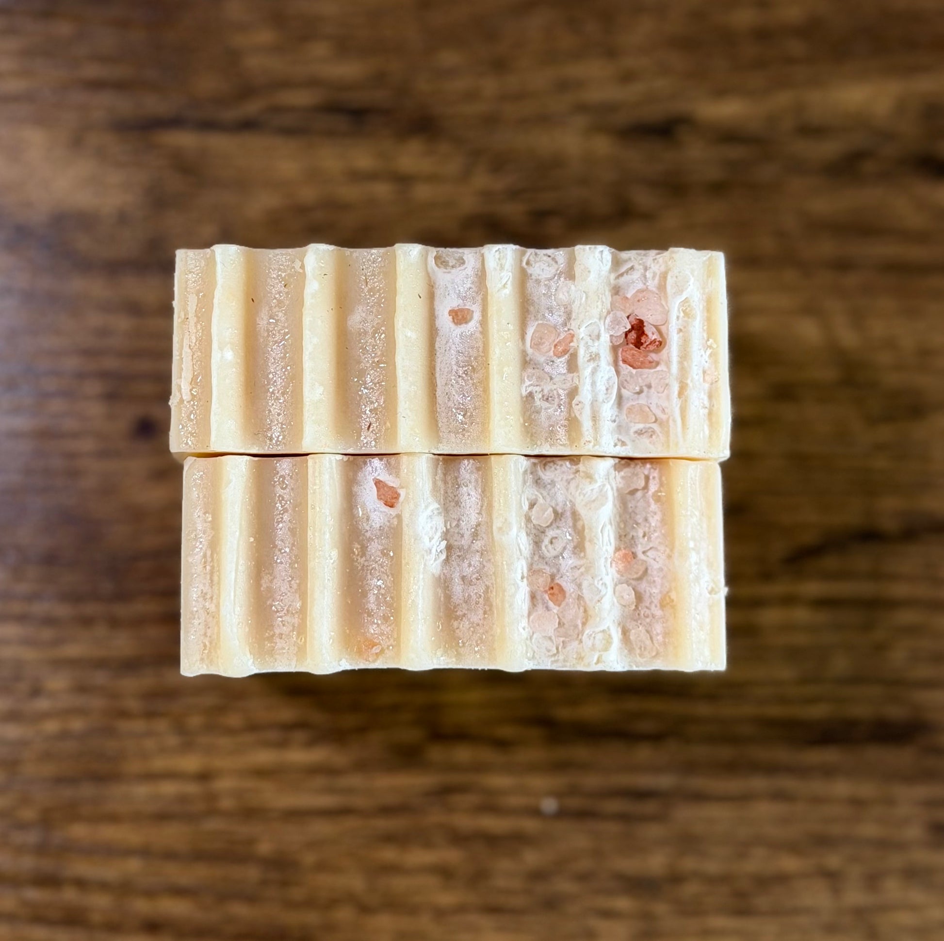 Two bars of soap with wave design and pink salt on top 